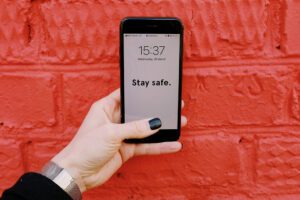 15 Tools To Run a Business Without Touching People 11 unrecognizable crop woman holding smartphone near red brick 3964506 scaled 1